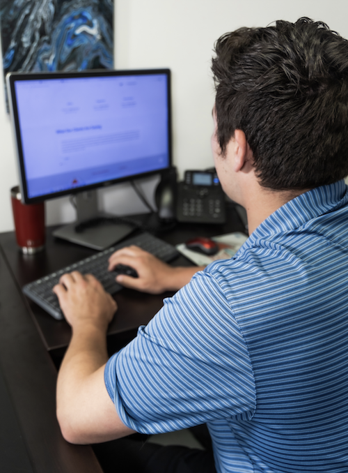 team member looking at computer we see back of his head