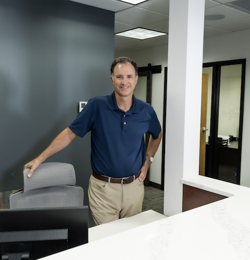 owner at receptionist desk smiling